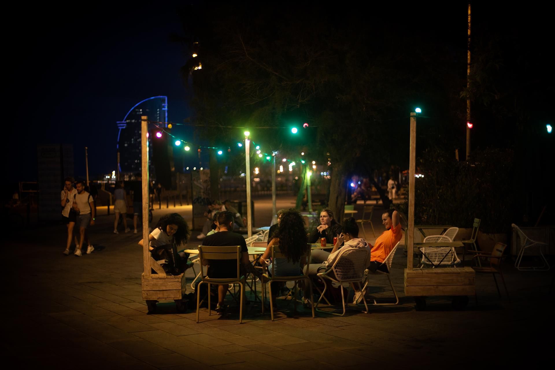 Varias personas en la terraza de un bar, frente a la playa de la Barceloneta. Foto EP.