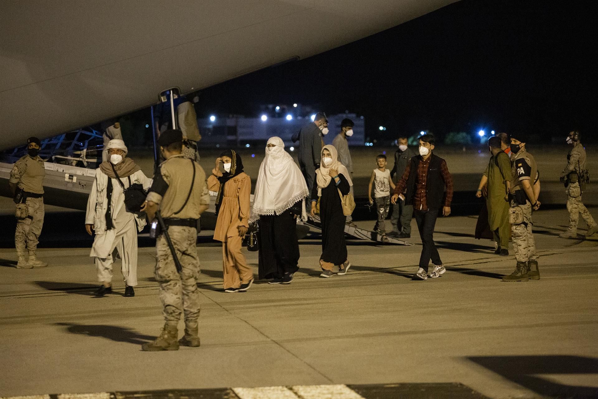 Varias personas repatriadas llegan a la pista tras bajarse del avión. | EP