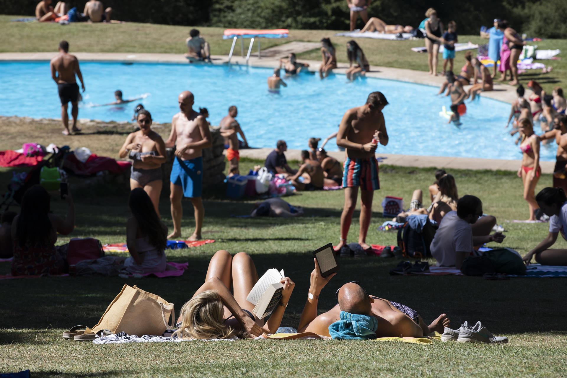 Varias personas disfrutan de un día de ocio en una piscina. | EP