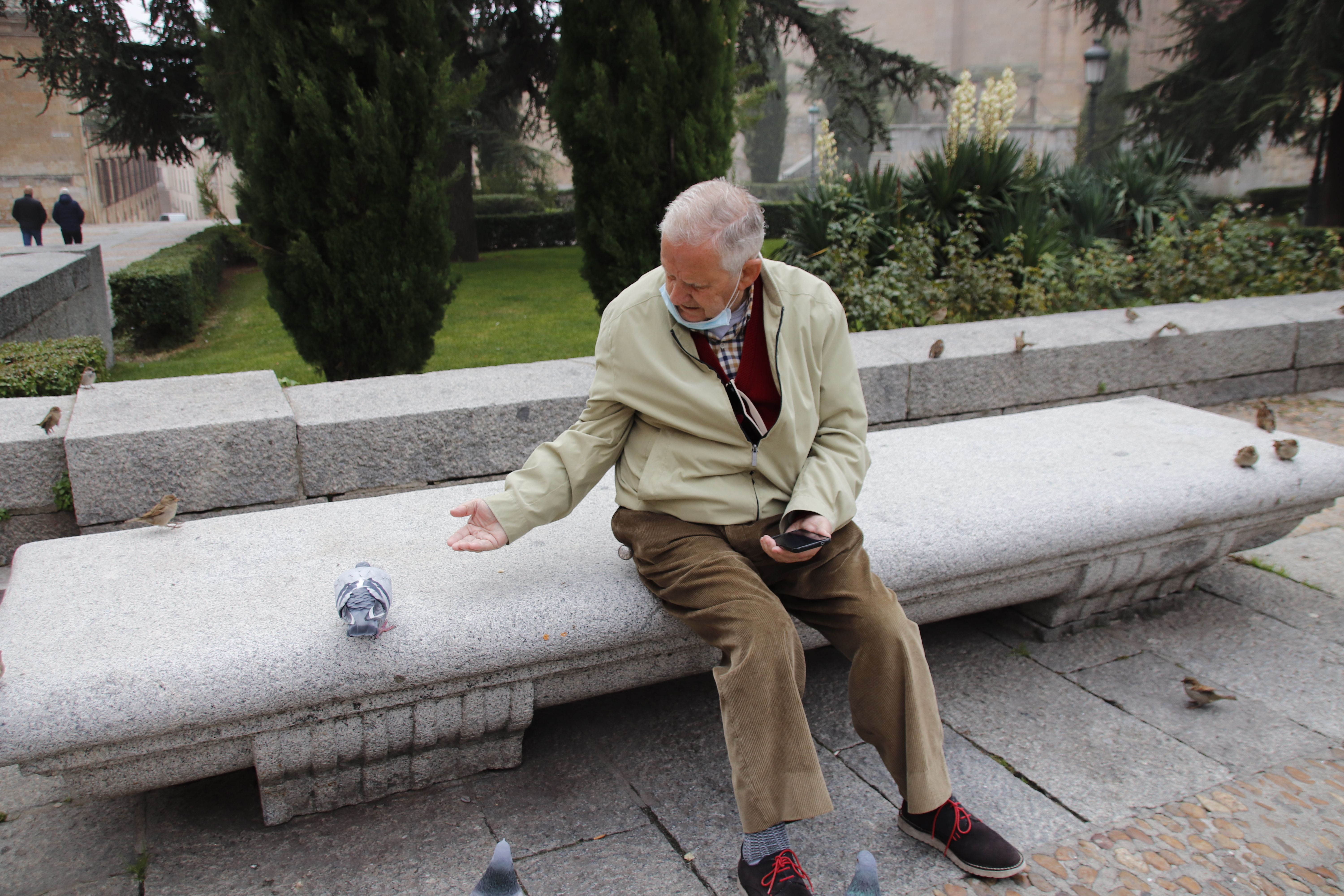 Señores mayores en la Plaza de Anaya dando de comer a las palomas en invierno | Foto: Andrea M