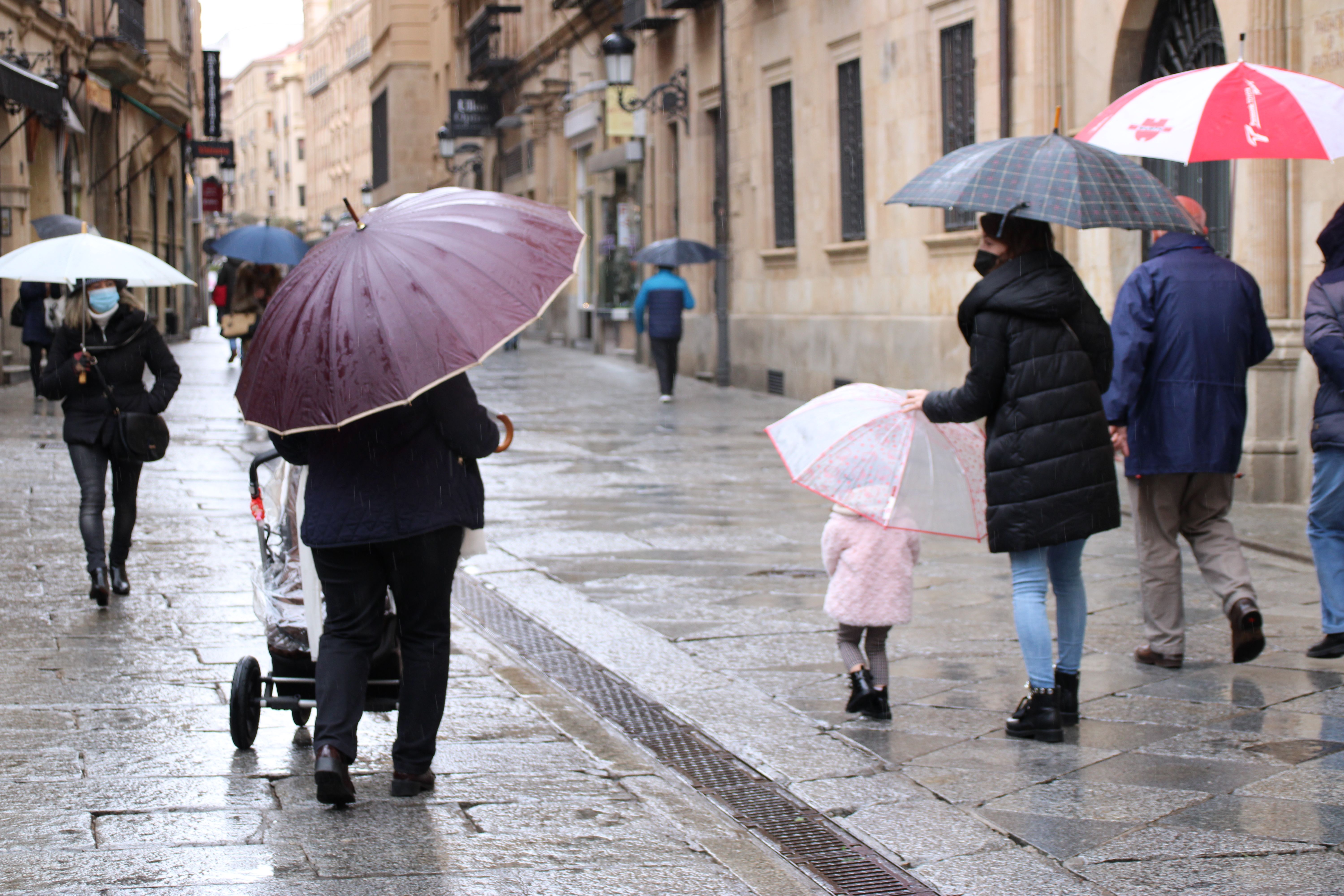 Familia pasea bajo la lluvia | Foto de archivo