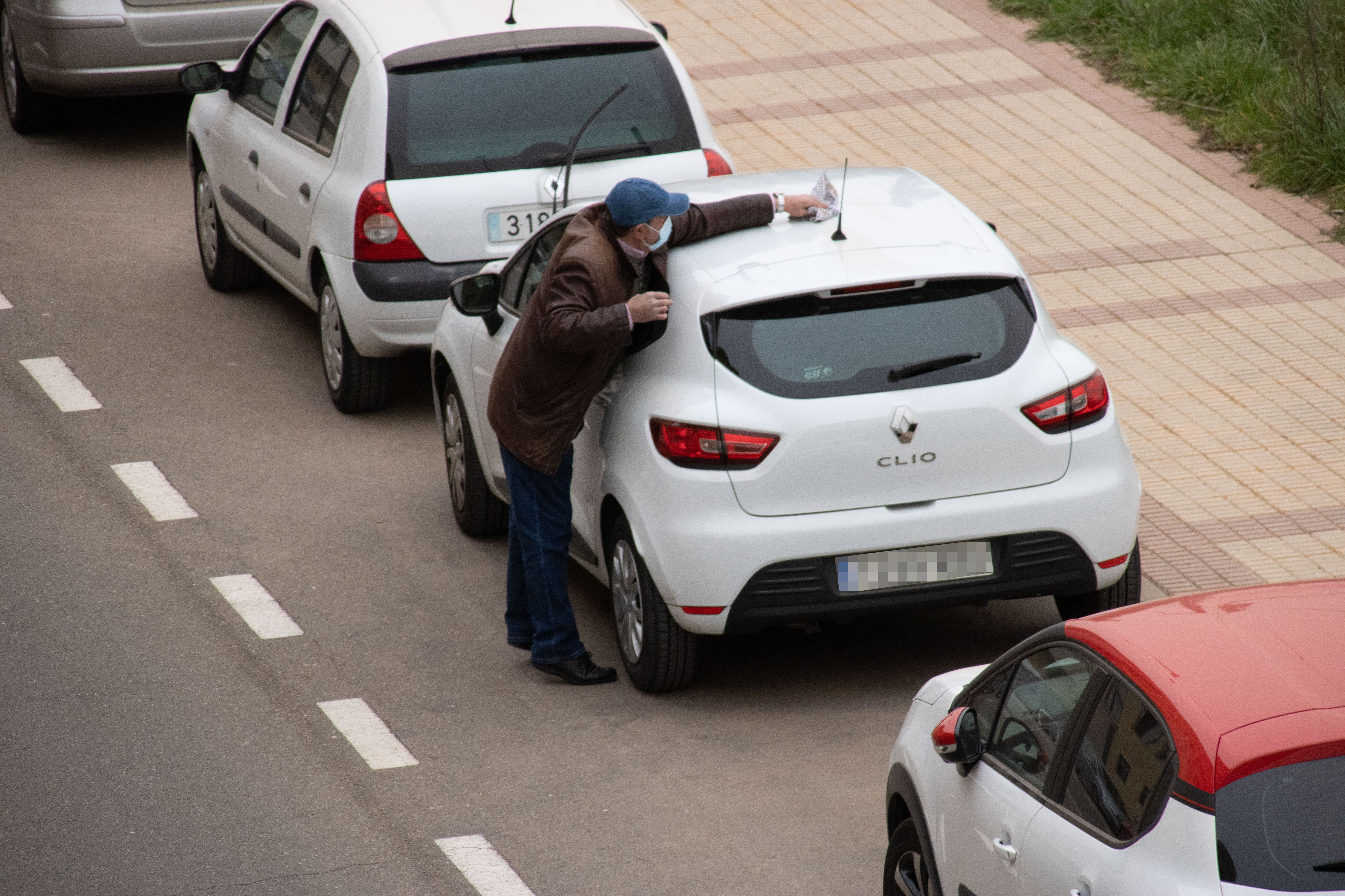 Señor limpia su coche de la arena del Sáhara en Salamanca