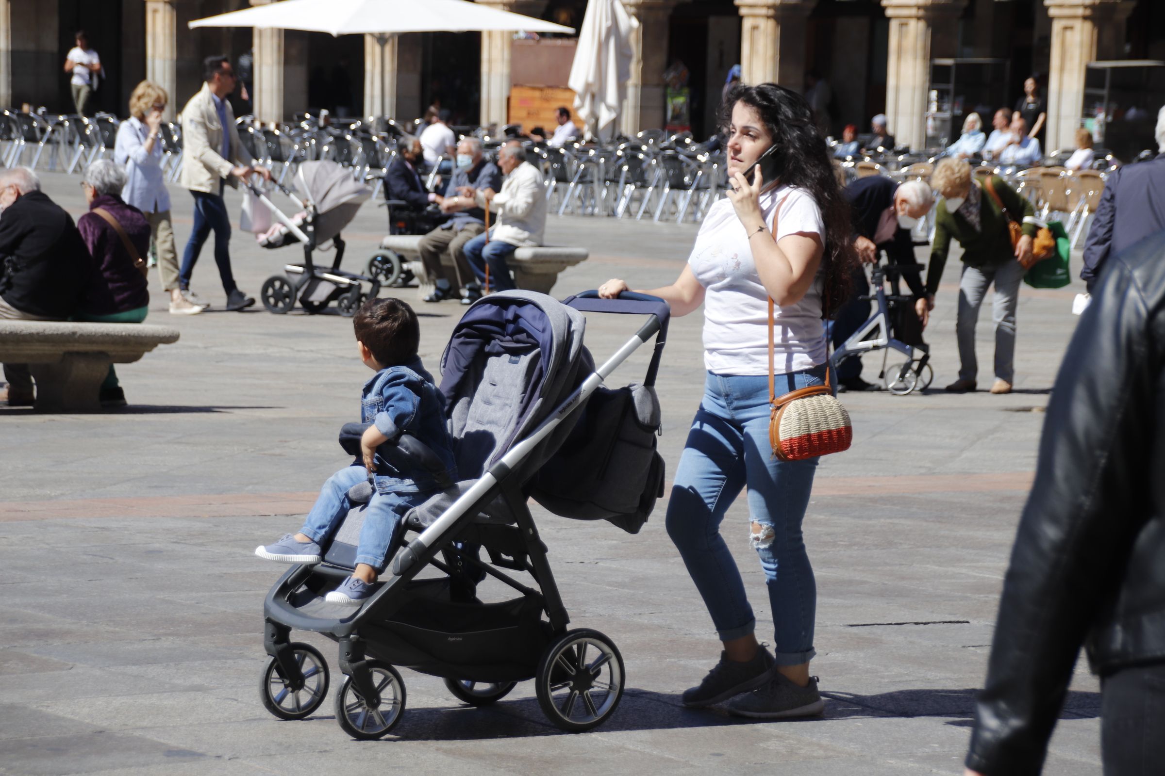 Gente por las calles de Salamanca con carrito de bebé