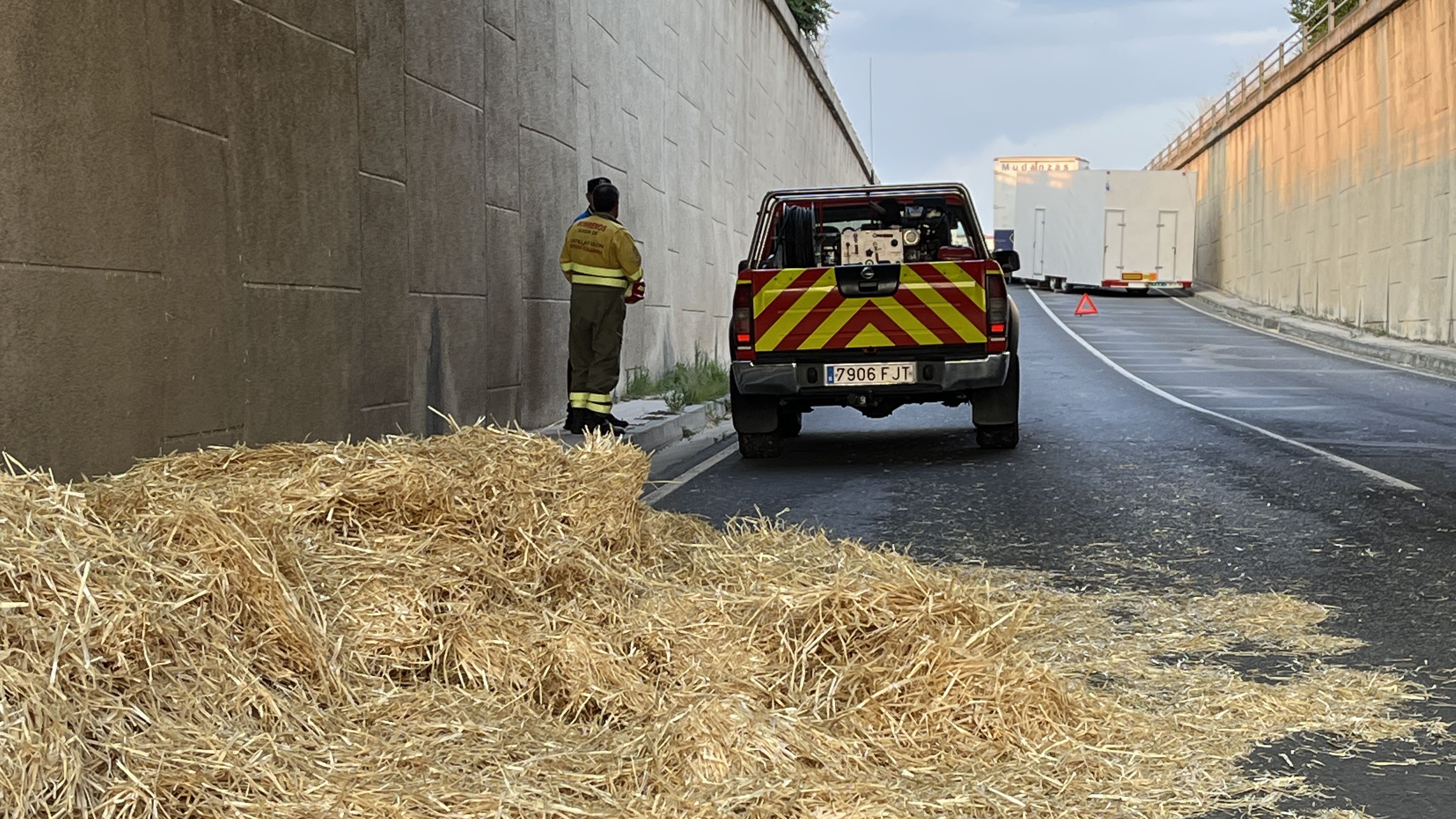 Un camión se queda parado en el acceso a Peñaranda por Alba mientras otro  pierde parte de la carga de paja