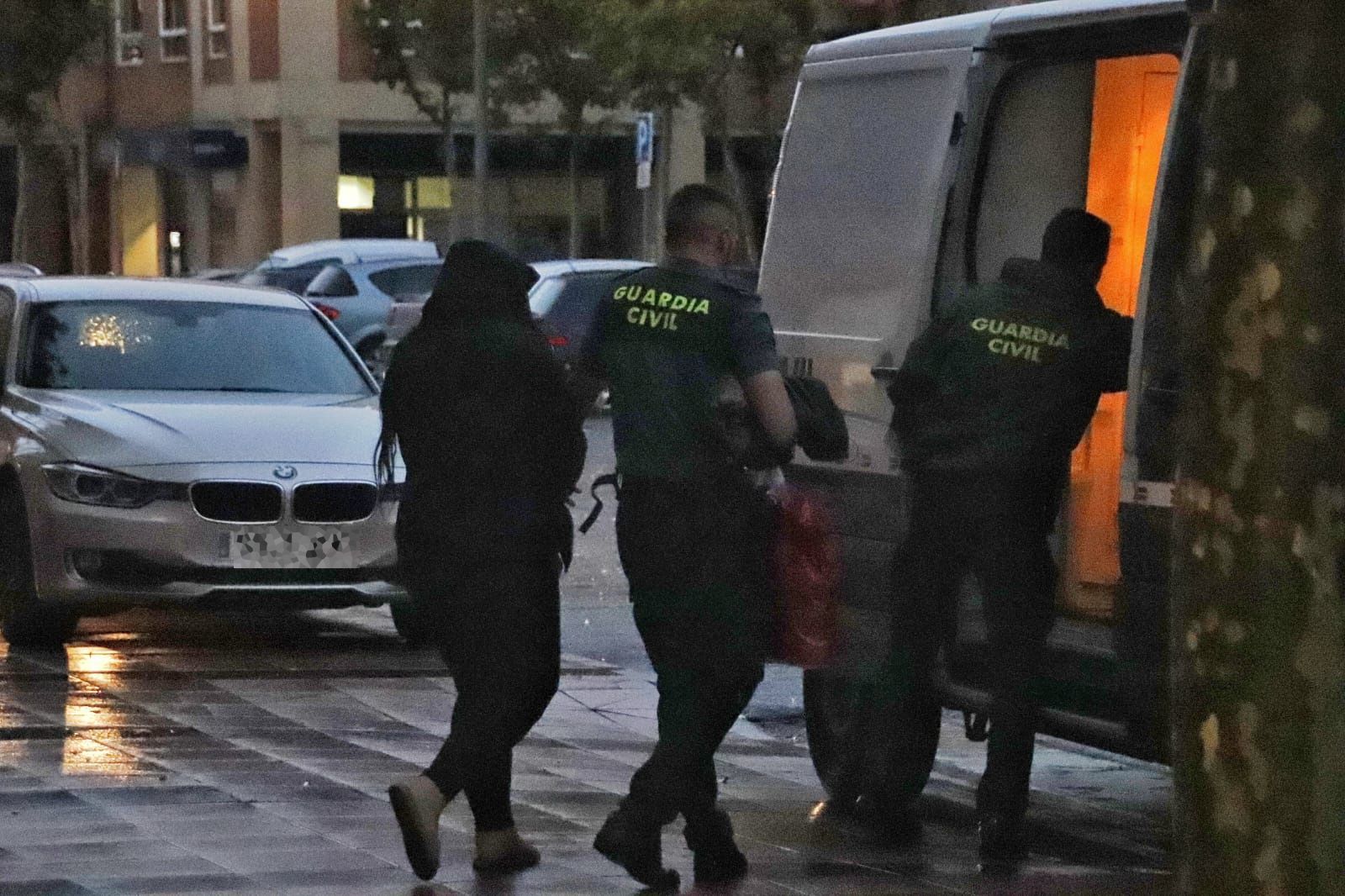 La mujer detenida entrando en el furgón de la Guardia Civil acompañada por los agentes