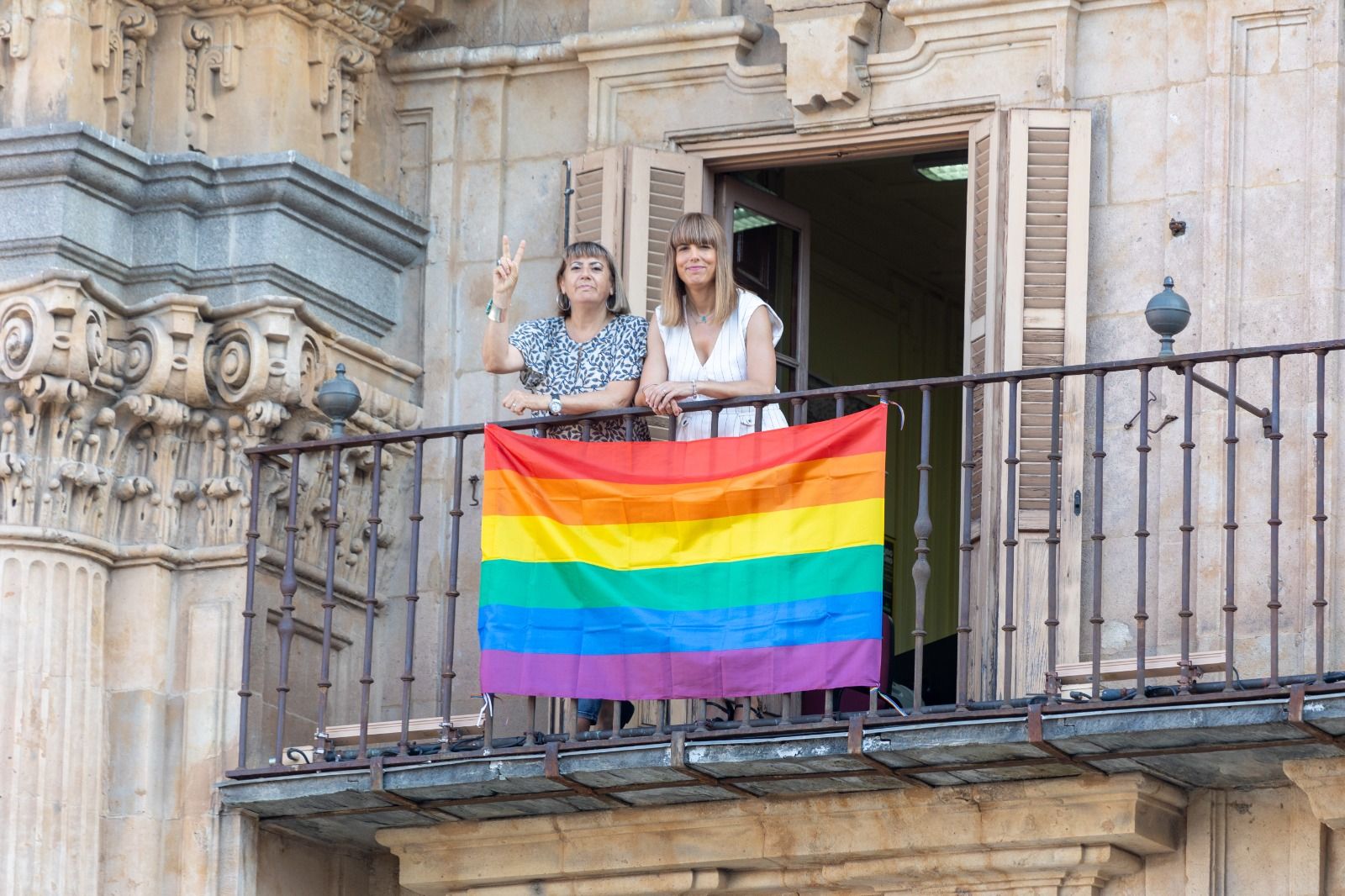 María García y María Sánchez posan junto a la bandera arcoiris