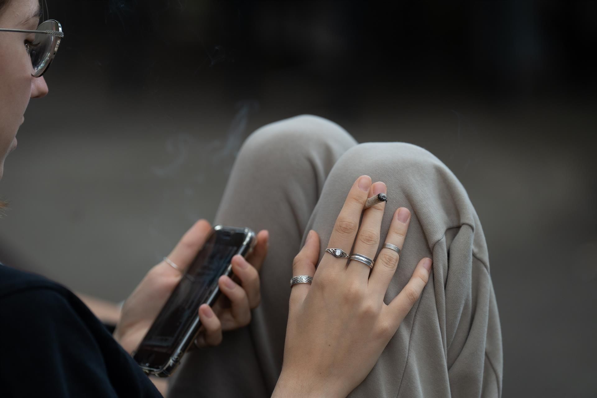 Una joven fuma y lee su móvil en las inmediaciones del colegio Pia Balmes, que la nueva normativa del Govern convertirá en espacio libre de humo, a 23 de septiembre de 2022, en Barcelona, Catalunya (España). La nueva normativa consiste en conver - David Zorrakino - Europa Press - Archivo