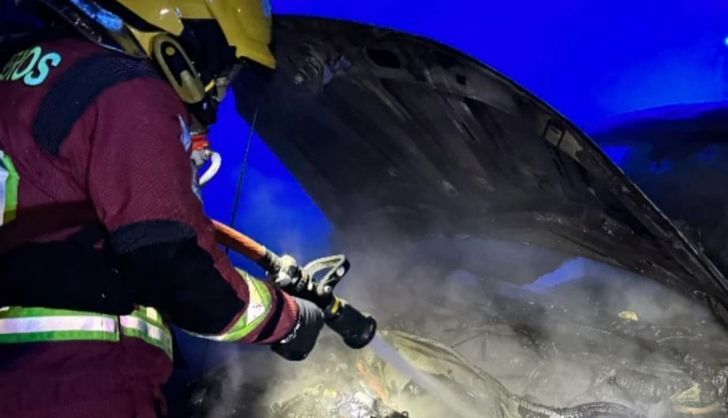 Bomberos de la Diputación apagando el fuego en un vehículo. Foto de archivo 