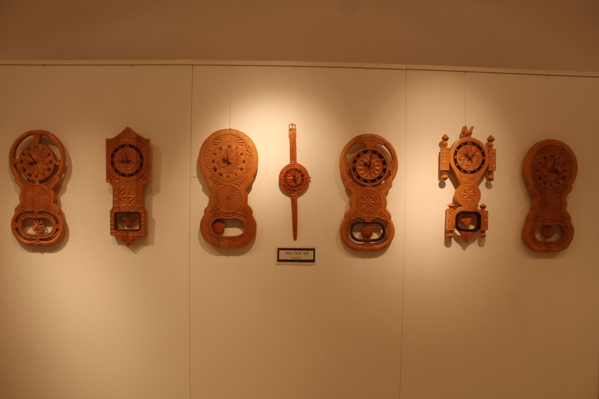 Reloj del urogayo, segundo por la derecha. Exposición de tallas de madera.