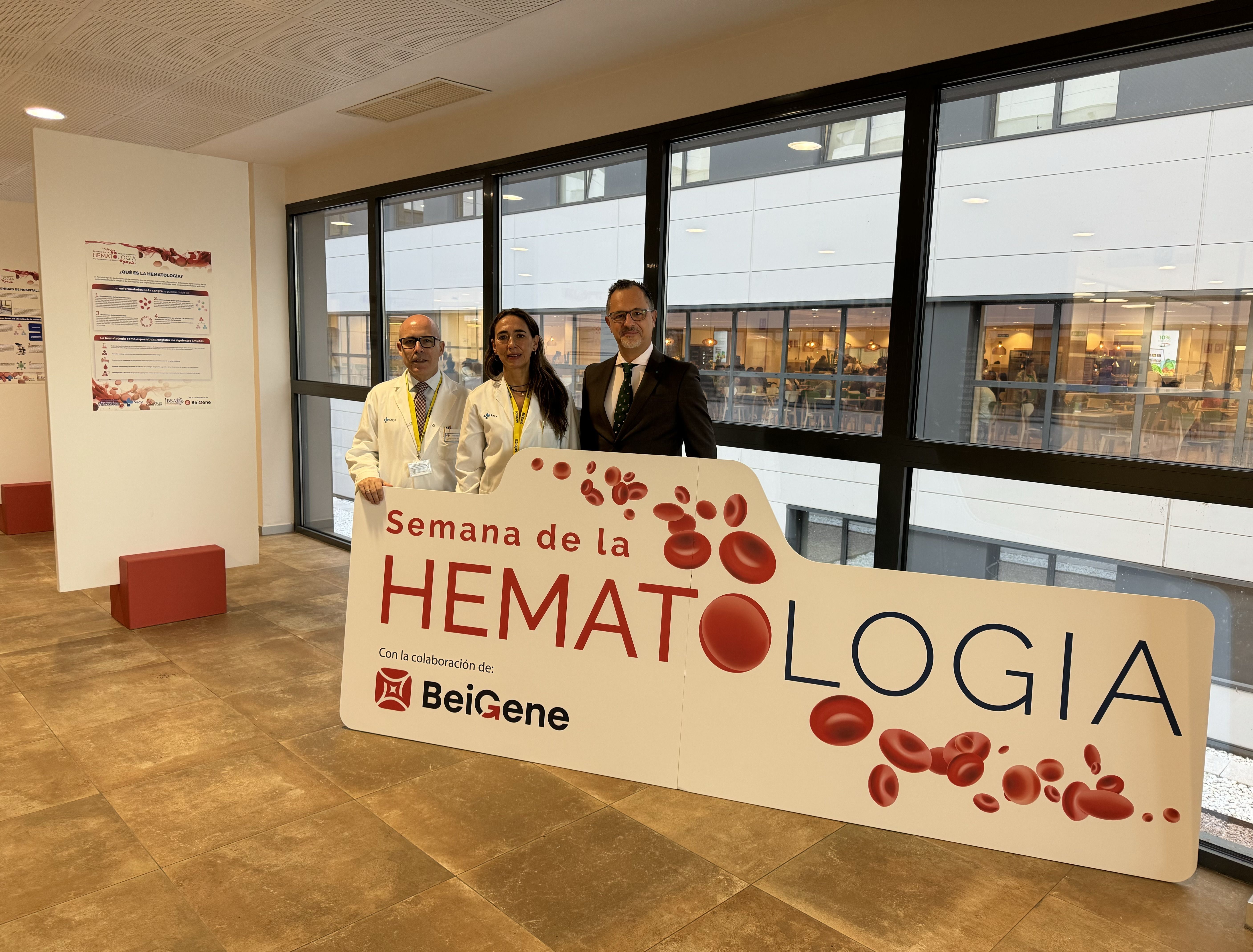 Carmen Rodríguez Pajares, directora gerente del CAUSA, Fermín Sánchez-Guijo, jefe de servicio de Hematología y Hemoterapia, y Miguel Cobo Vázquez, Director Nacional de Ventas de BeiGene para España, posan con el cartel corpóreo que marca el inicio de la exposición de la Semana de la Hematología.