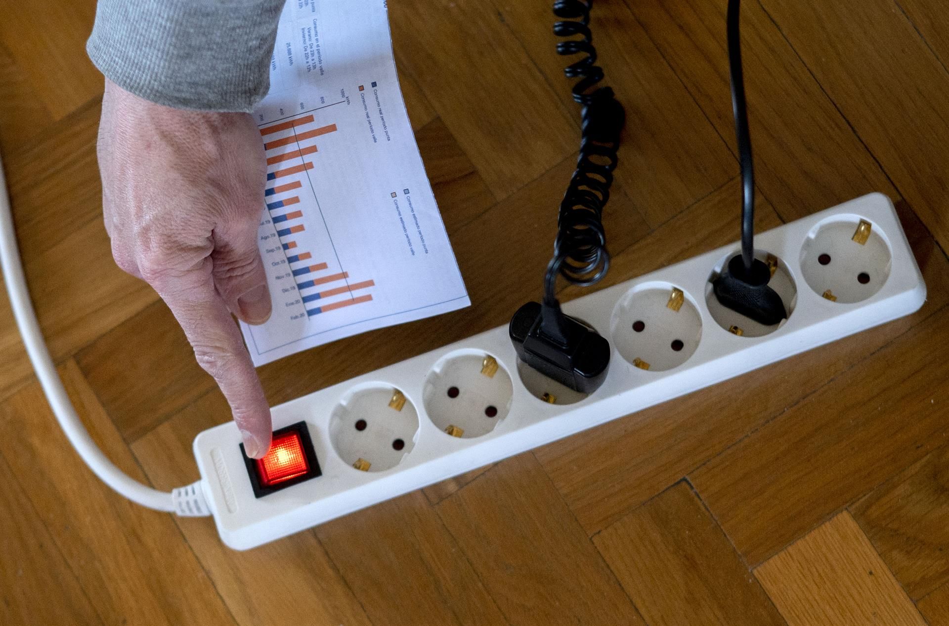 Archivo - Un hombre enciende una largadera con varios enchufes con una factura de luz en la mano, a 3 de enero de 2022, en Madrid, (España). El precio medio de la electricidad en el mercado mayorista vuelve a subir hoy, en concreto un 9,88% con respecto a - Alberto Ortega - Europa Press - Archivo