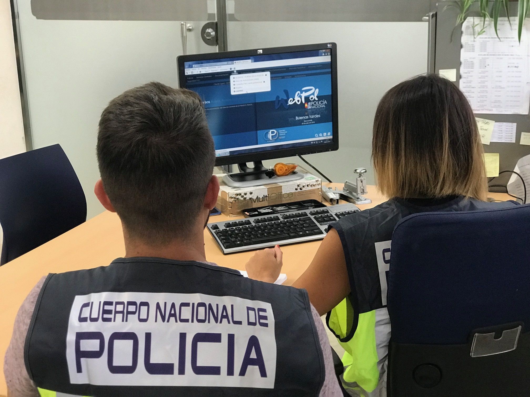  Agentes de la Policía Nacional delante de un ordenador 