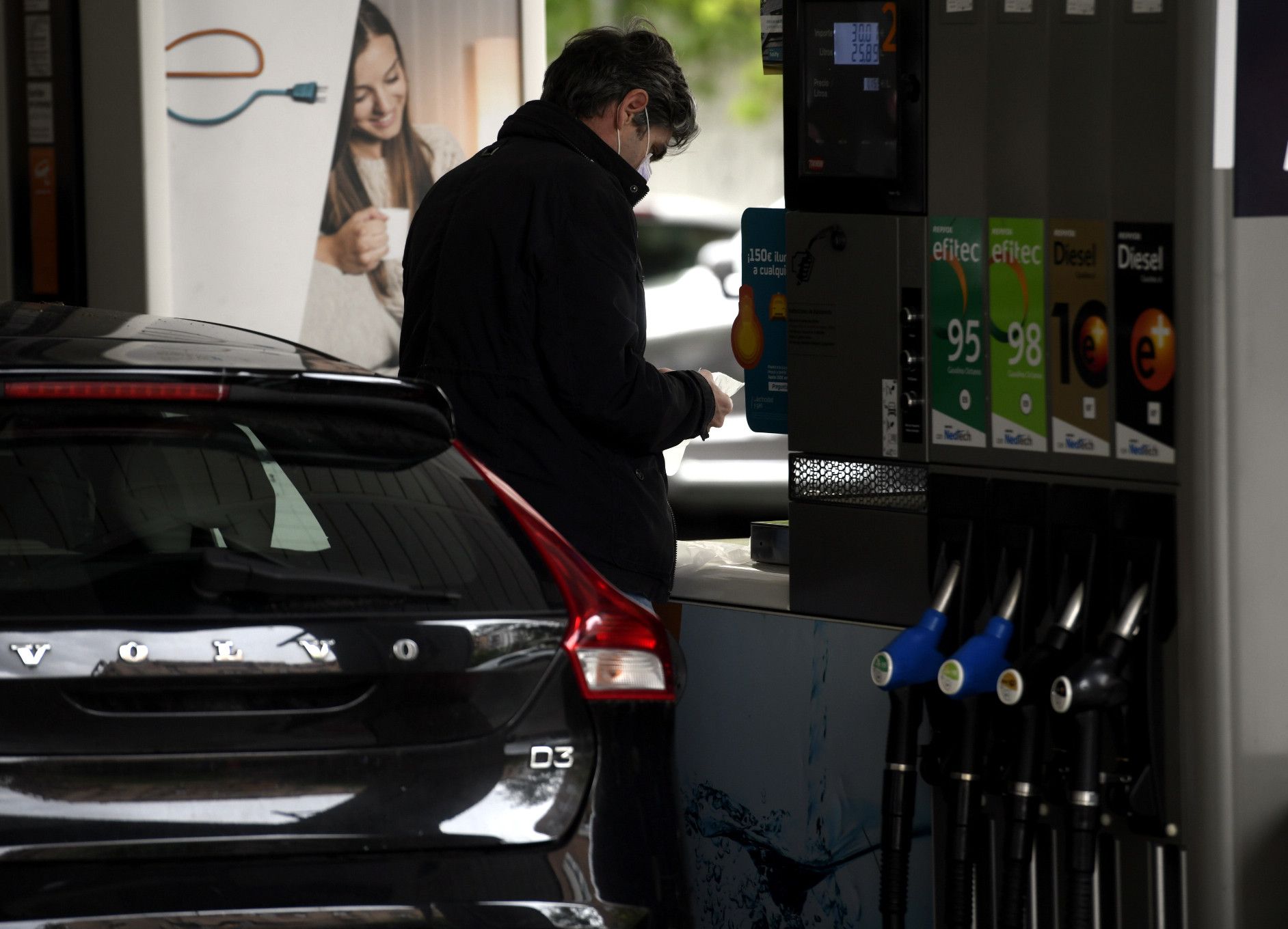  Un hombre echa gasolina a su coche en una gasolinera 