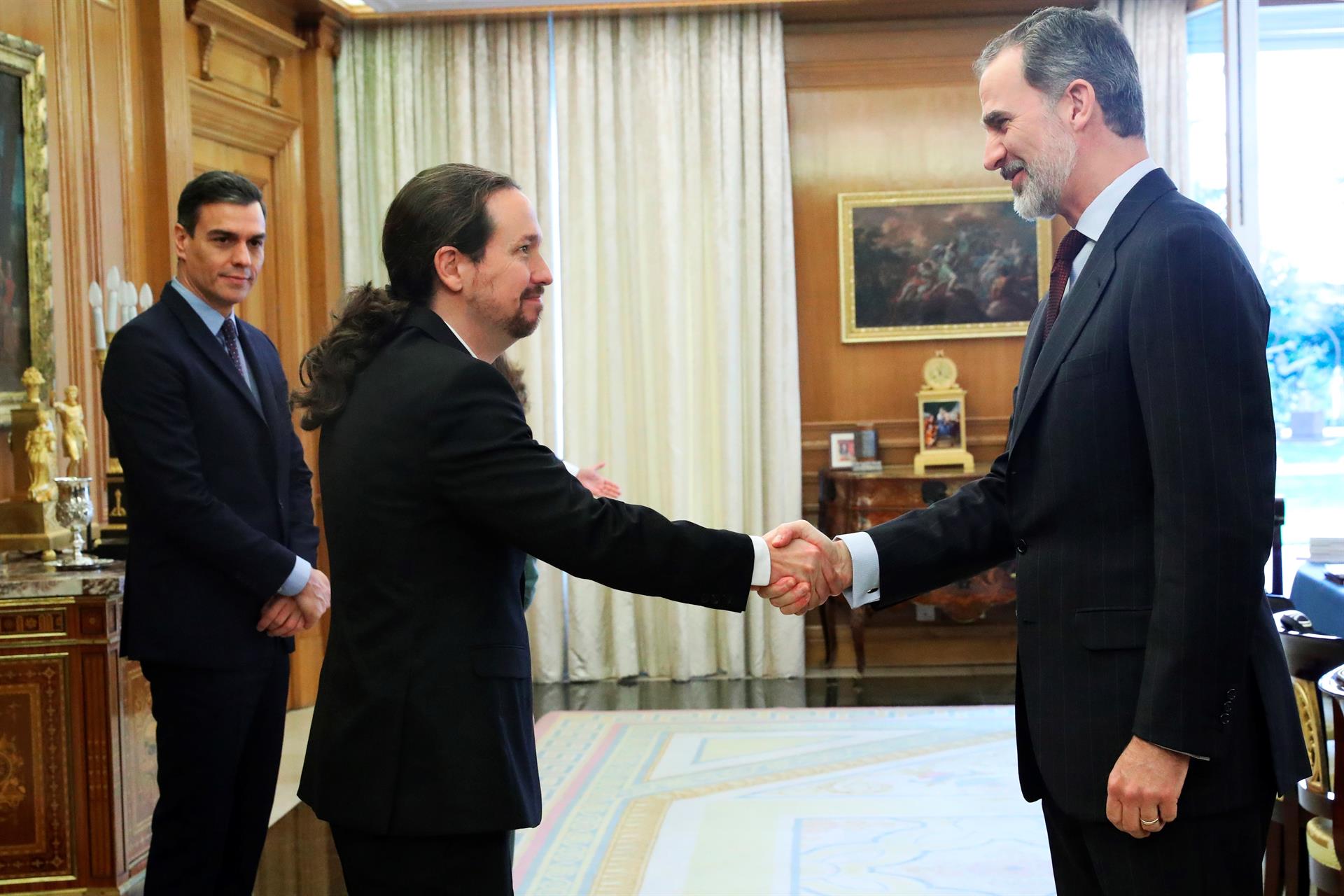 Saludo entre Pablo Iglesias y Felipe VI; de fondo, Pedro Sánchez. Foto de archivo.