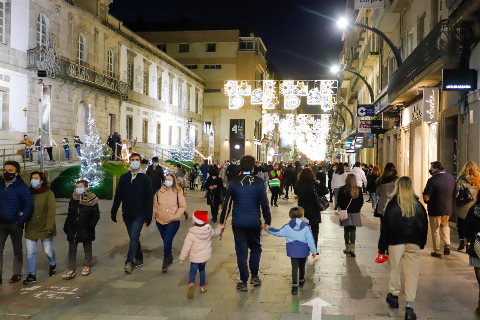 Transeúntes bajo las luces navideñas. | EP