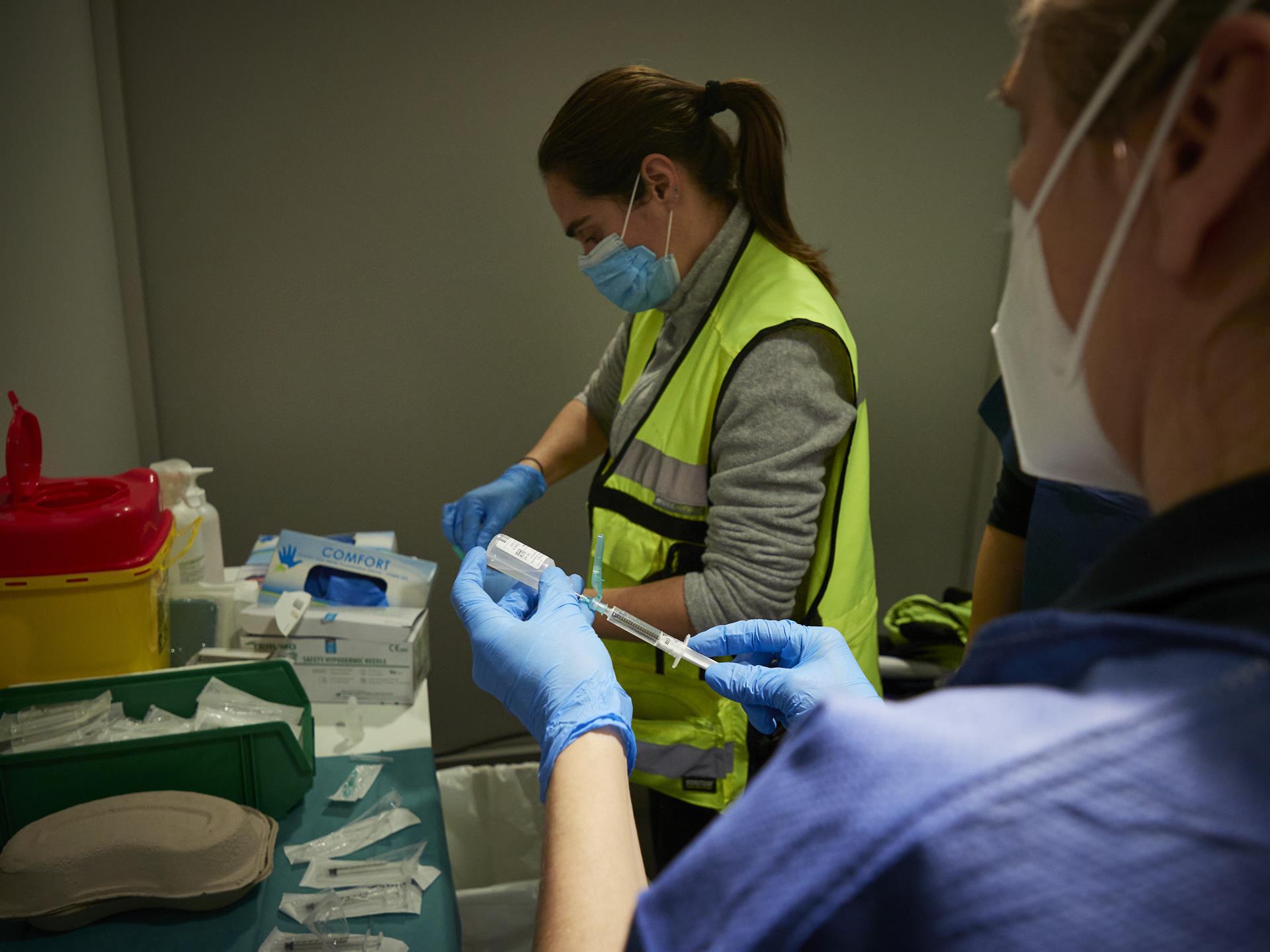 Dos trabajadoras sanitarias en un dispositivo para administrar la vacuna contra el COVID-19