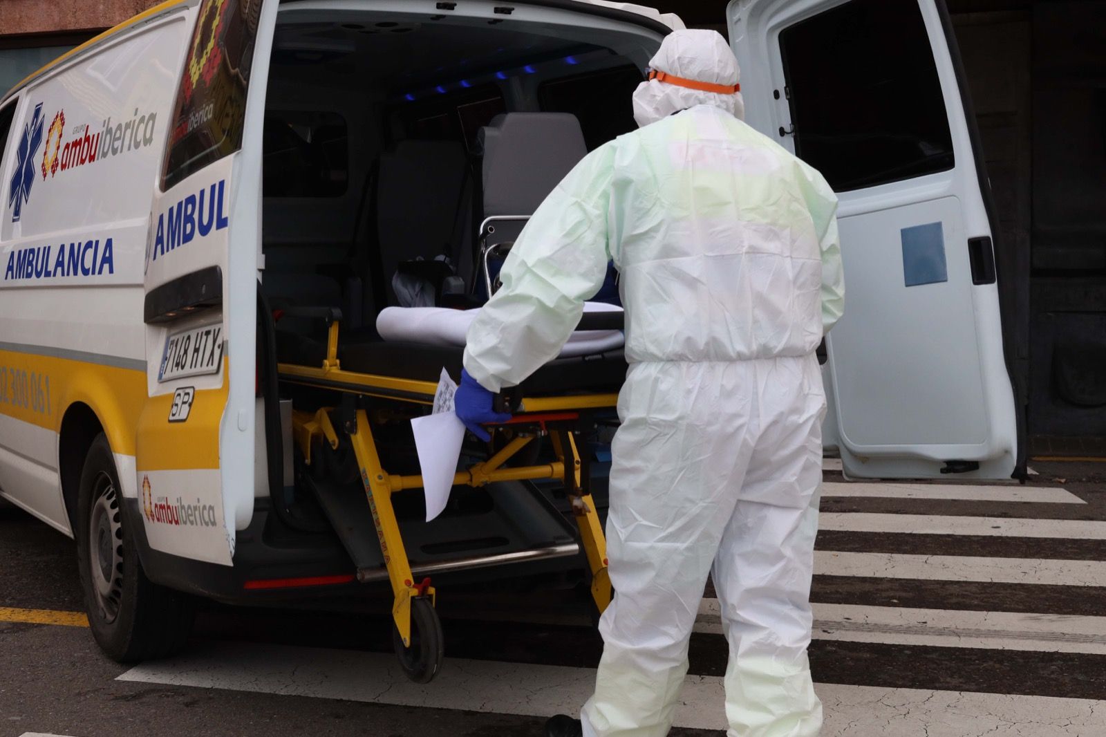 Un camillero a las puertas del hospital Clínico protegido con un EPI frente al COVID 19